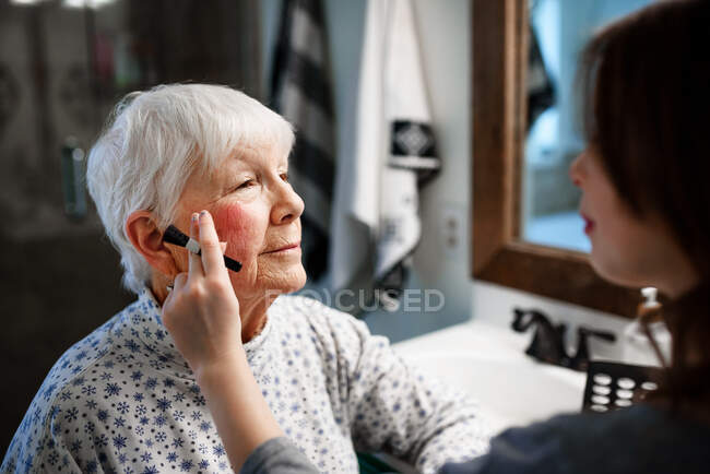 Mädchen schminken ihre Großmutter — Stockfoto