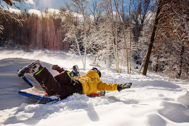 Boy sledding down a hill in the snow, EUA — Fotografia de Stock