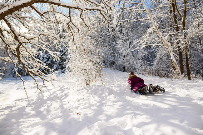 Женщина катается на санках по снегу, США — стоковое фото