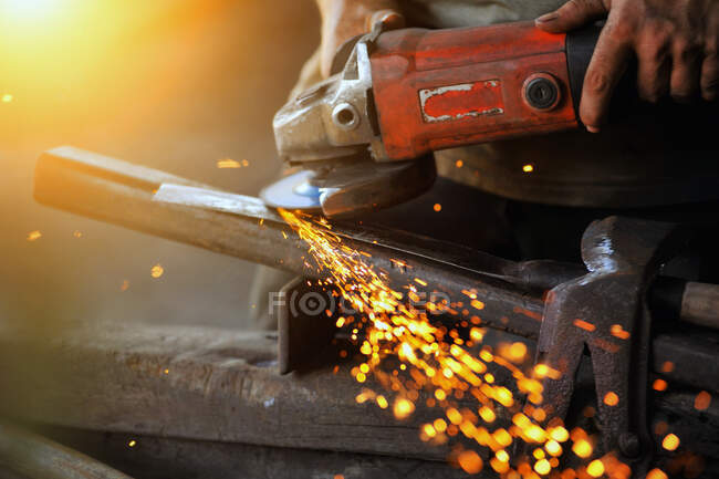 Close-up of a man using a grinder in a workshop, Thailand — Stock Photo