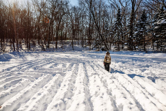Мальчик идет по снежному лабиринту, США — стоковое фото