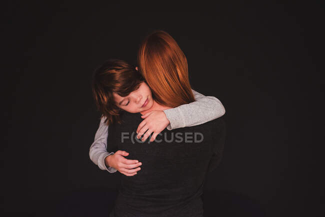 Retrato de uma mãe abraçando seu filho — Fotografia de Stock