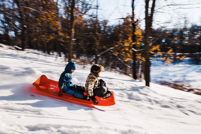 Two boys sledding down a hill, USA — Stock Photo