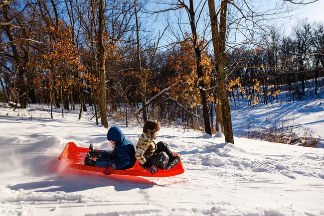 Two boys sledding down a hill, USA — Stock Photo