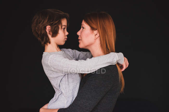 Retrato de una madre abrazando a su hijo - foto de stock