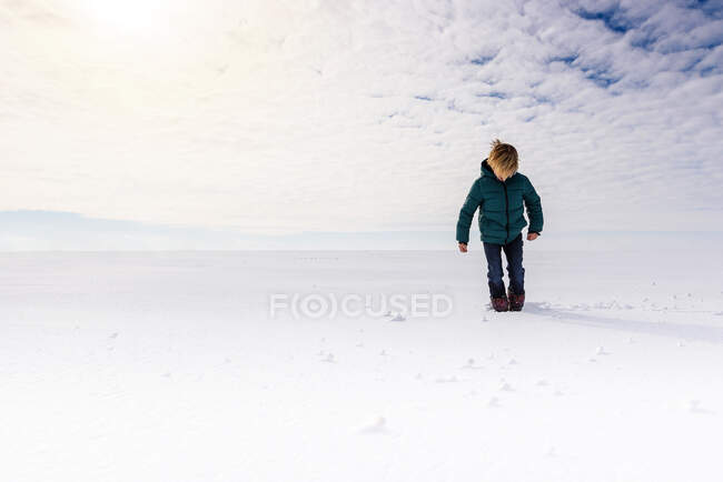 Garçon marchant dans un champ neigeux, États-Unis — Photo de stock