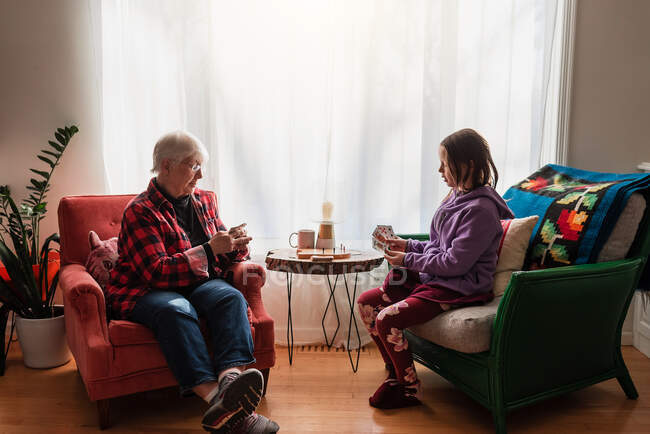 Grandmother and granddaughter playing a card game — Stock Photo