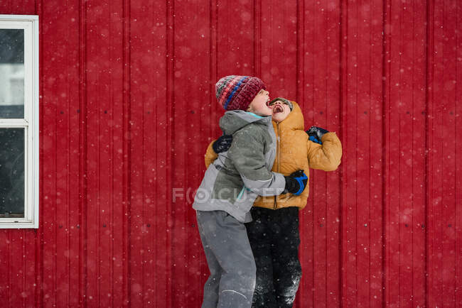 Due bambini che catturano fiocchi di neve in bocca, USA — Foto stock
