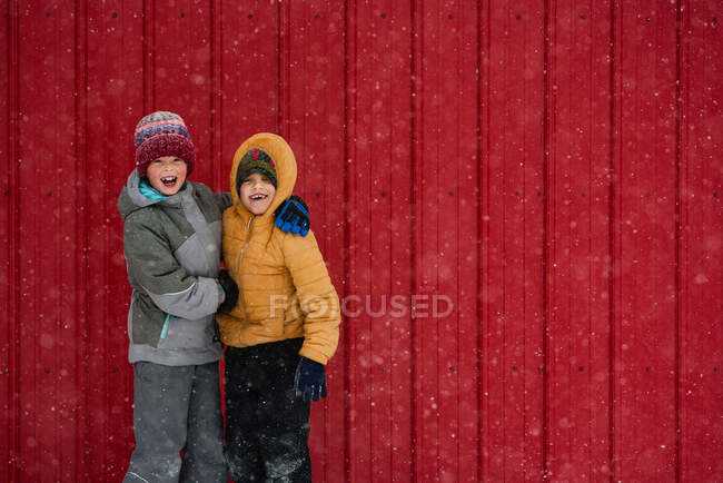 Duas crianças felizes brincando na frente de uma casa vermelha, EUA — Fotografia de Stock