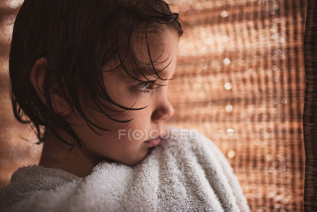 Nahaufnahme eines Jungen, der nach einem Bad in ein Handtuch gewickelt ist — Stockfoto
