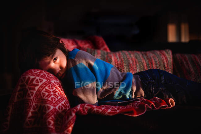 Хлопчик лежить на дивані розслабляючий — стокове фото