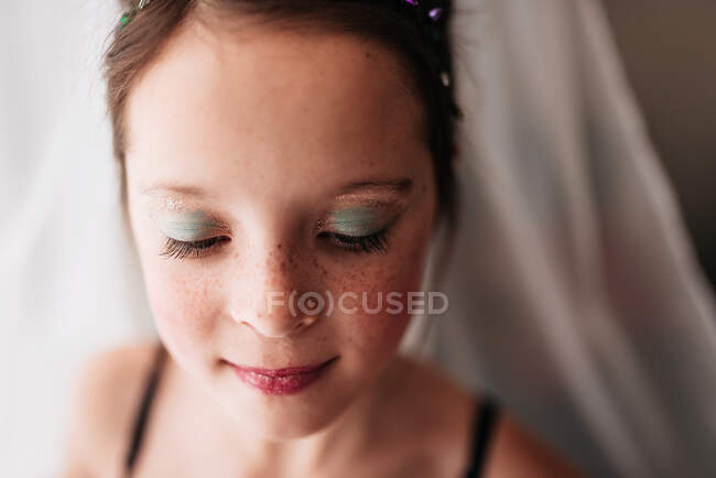 Porträt eines jungen Mädchens mit Make-up, das vor einem Vorhang steht — Stockfoto