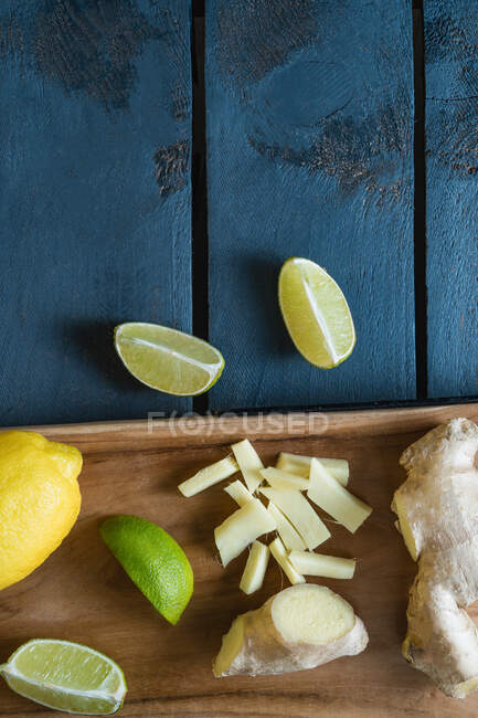 Gingembre, citron et citron vert sur une planche à découper — Photo de stock