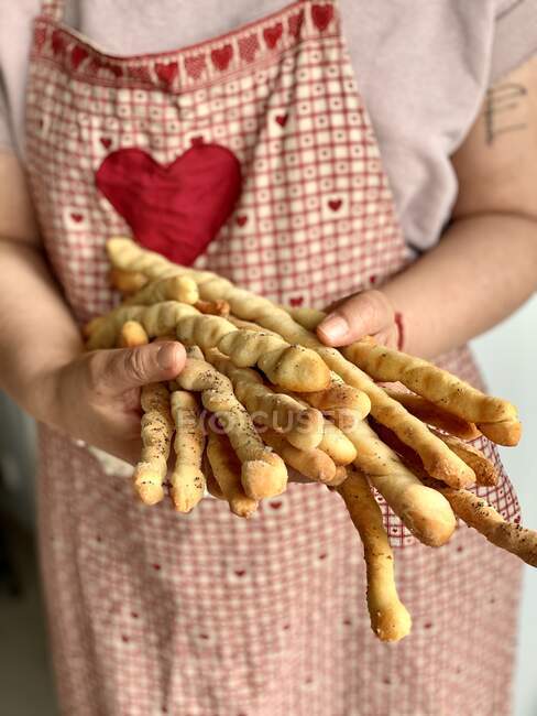 Woman holding freshly baked bread sticks — Stock Photo