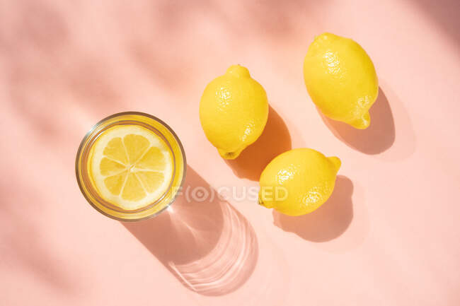 Bicchiere di acqua al limone con limoni — Foto stock