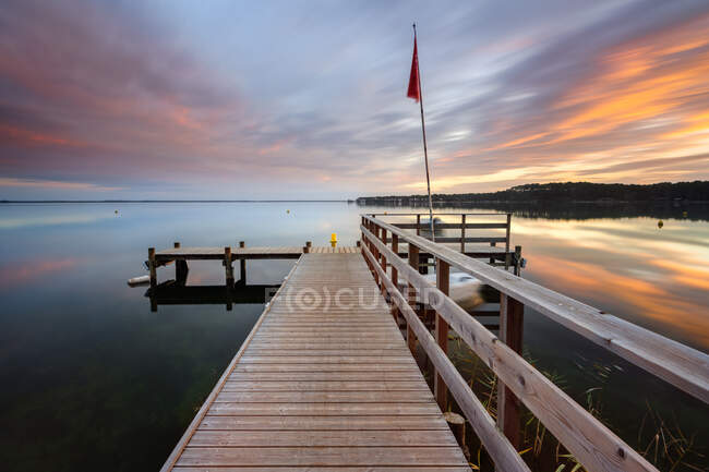 Longue exposition de jetée en bois au coucher du soleil, Lac de Carcans, Gironde, France — Photo de stock