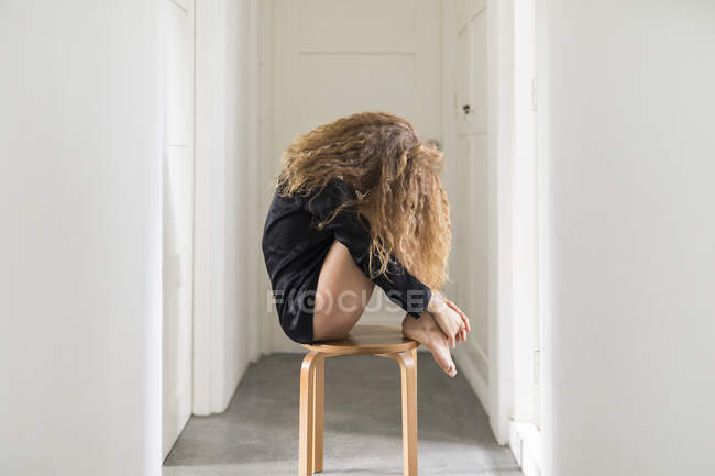 Mulher bonita sentada em uma cadeira em seu corredor — Fotografia de Stock