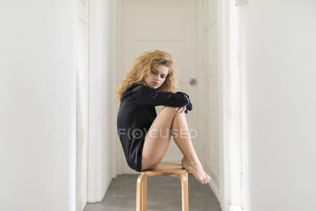 Beautiful woman sitting on a chair in her hallway — Stock Photo