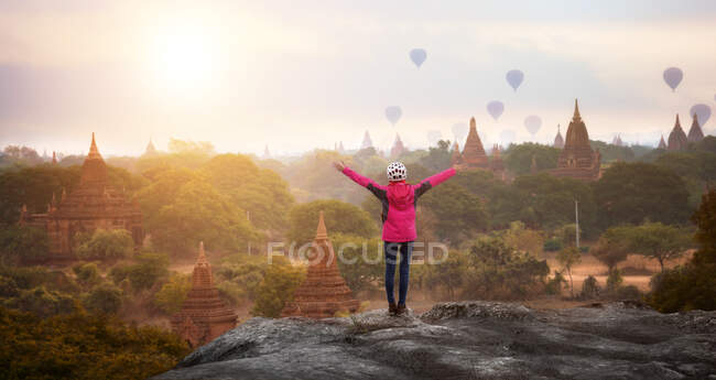 Visão traseira de uma mulher com braços estendidos, Bagan, Mandalay, Myanmar — Fotografia de Stock