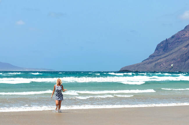 Schöne Frau im Sommerkleid am Strand von Famara, Lanzarote, Kanarische Inseln, Spanien — Stockfoto