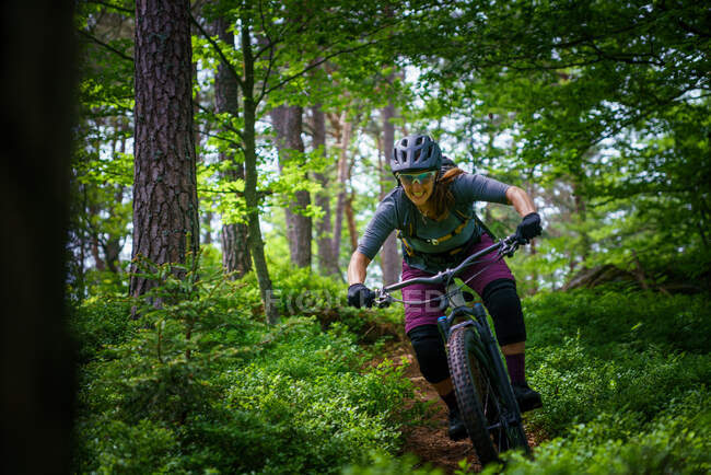Woman mountain biking through the forest, Klagenfurt, Carinthia, Austria — Stock Photo