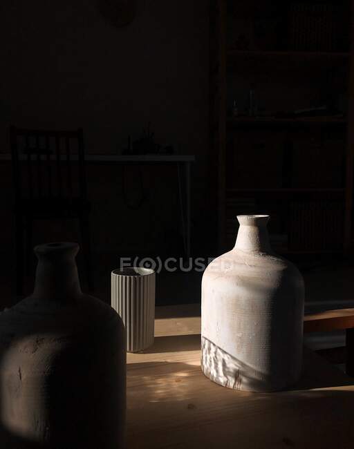 Три вазы на столе под солнечным светом — стоковое фото