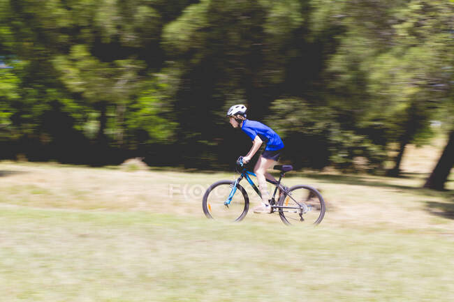 Boy cycling through rural landscape, Spain — Stock Photo