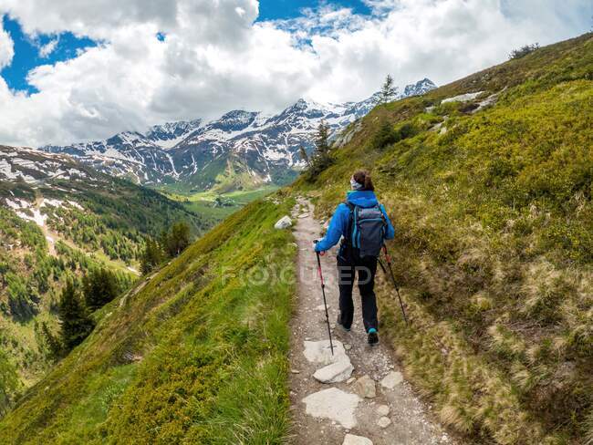 Junge Frau wandert auf Fußweg in den österreichischen Alpen bei Gastein, Salzburg — Stockfoto