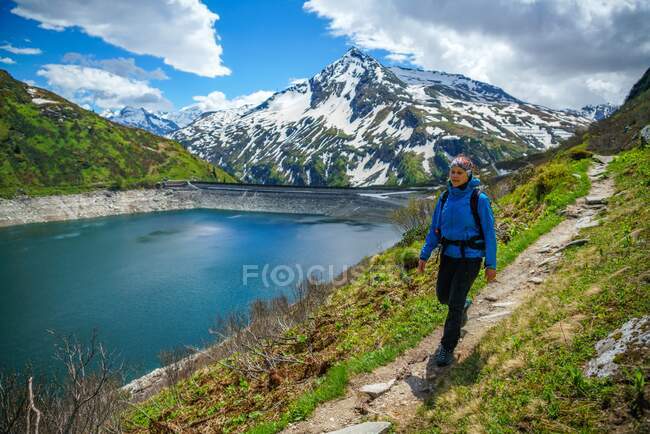 Woman hiking along a trail by Lake Bockhartsee, Sportgastein, Salzburg, Austria — Stock Photo