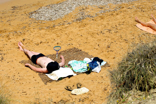 Due persone prendere il sole sulla spiaggia, Golden Bay, Malta — Foto stock
