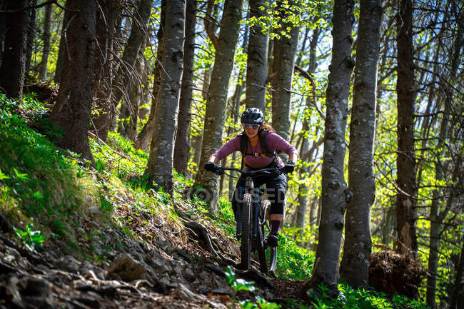 Mulher mountain bike através da floresta, Salzburgo, Áustria — Fotografia de Stock