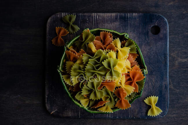 Bowl of dried multi coloured farfalle pasta in a bowl — Stock Photo