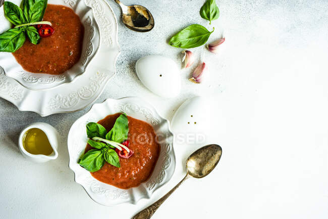 Traditionelle spanische Tomatensuppe Gazpacho derved in ceranic bowl with fresh basil leaves on stone background with copy space — Stockfoto