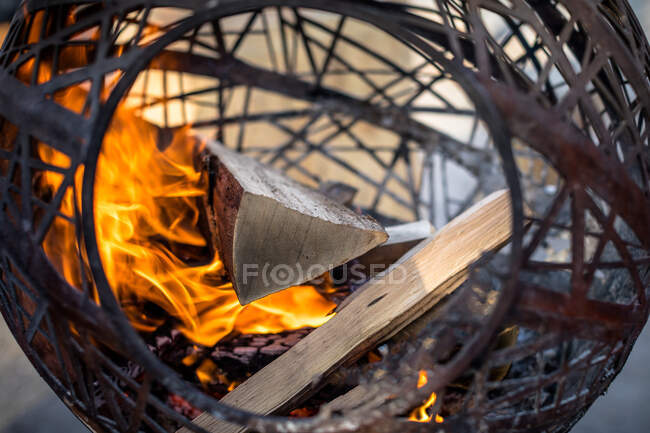 Primer plano de la quema de madera en una chimenea circular al aire libre, Suiza - foto de stock