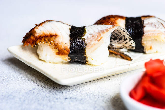 Gros plan de deux anguilles nigiri fumées sur une assiette — Photo de stock