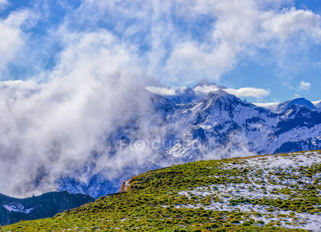 Clouds over snowcapped mountain landscape, Switzerland — Stock Photo