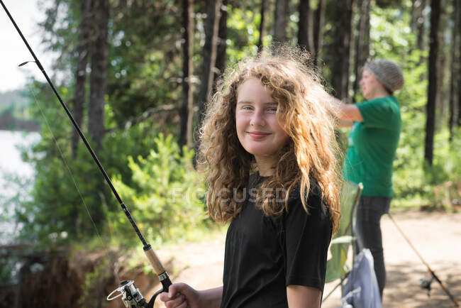 Woman standing by a lake fishing with her daughter, Oregon, USA — Stock Photo