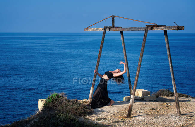 Woman standing by sea dancing, Malta — Stock Photo