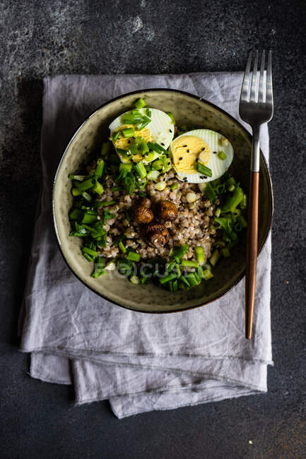 Tigela com alimentos saudáveis e orgânicos com trigo sarraceno verde, ervas e ovos — Fotografia de Stock