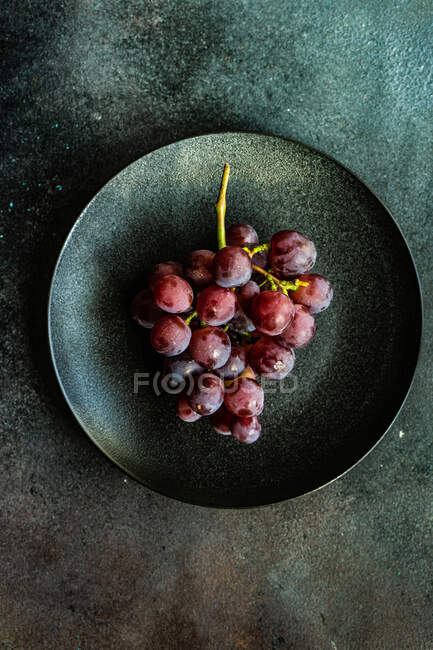 Fruta de uva fresca orgânica no prato como um conceito de alimento saudável — Fotografia de Stock