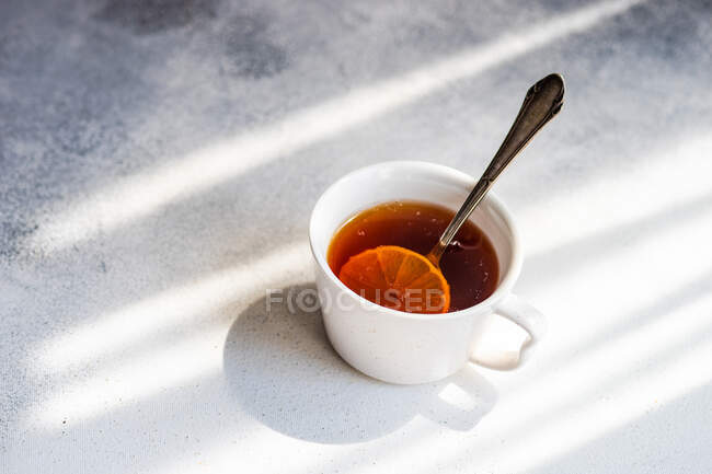 Крупный план чашки черного чая с ломтиком лимона — стоковое фото