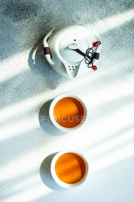 Zwei Tassen Tee und eine Teekanne auf einem Tisch — Stockfoto
