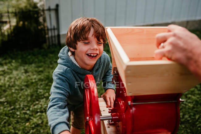 Boy helping press apples to make cider, USA — Stock Photo