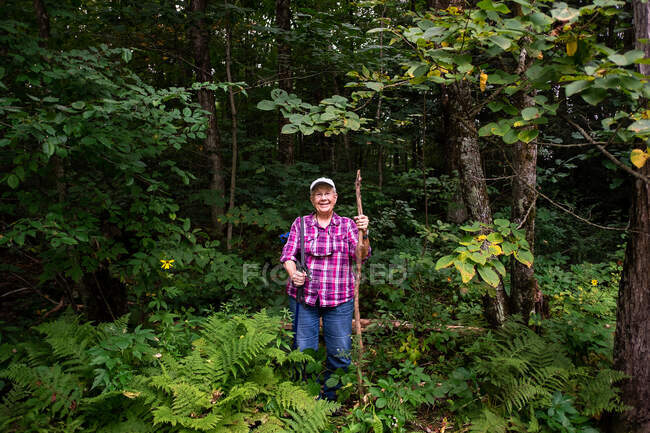 Porträt einer lächelnden Seniorin beim Wandern im Wald, USA — Stockfoto