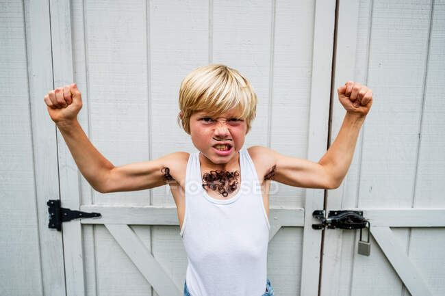 Портрет счастливого мальчика в костюме мускулистого человека, США — стоковое фото