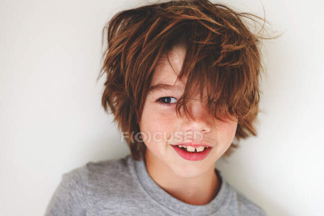 Портрет улыбающегося мальчика с грязными волосами — стоковое фото