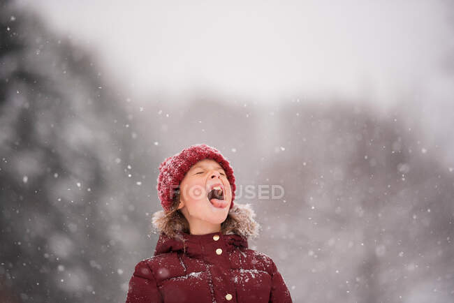 Menina de pé ao ar livre pegando neve em sua boca, Wisconsin, EUA — Fotografia de Stock