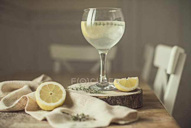 Copo de limonada caseira e limões frescos em uma mesa — Fotografia de Stock
