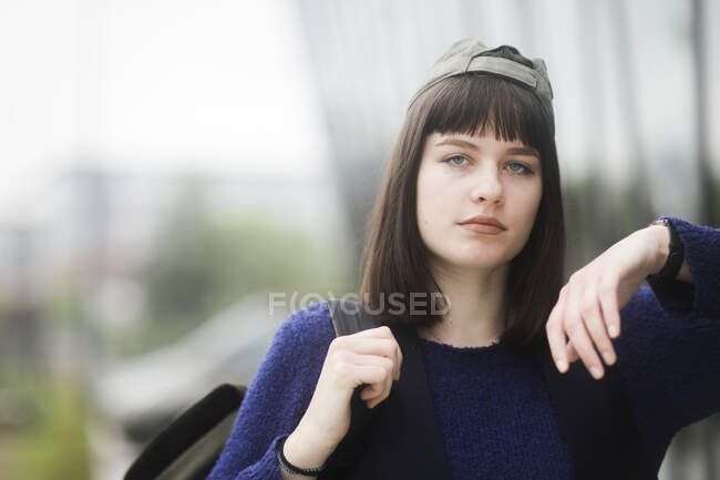 Portrait of a woman standing outdoors leaning against a wall outdoors, Germany — Stock Photo