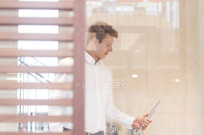 Salesman in a showroom showing a shower attachment, Germany — Stock Photo